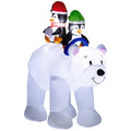 Inflated white polar bear carrying two penguins in red and green hats on a plain background