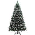 Studio shot of a 7ft snow-dipped pine Christmas tree on a black metal stand