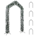 Snow-flocked Christmas tree arch with four metal ground stakes on a white background