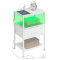 Cloud White bedside table with one fabric drawer and a green-lit open shelf, styled with an alarm clock and a charging phone