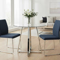 Clear glass round dining table with silver metal base styled in a modern living space