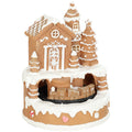 Studio shot of the brown gingerbread house Christmas village with rotating train