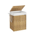 Natural rattan laundry basket standing open with its white fabric liner and carry handle visible