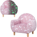 Pink kids armchair with a glow-in-the-dark star and moon pattern, shown in daylight and glowing
