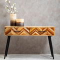 Natural mango wood console table with two drawers and black iron legs in a styled hallway