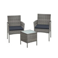Grey rattan garden set with two cushioned armchairs and a square glass top table on white