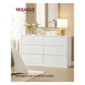 Snow White 6 drawer dresser in a bedroom with a gold lamp, mirror and flowers on top