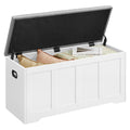 White storage bench with the grey cushioned lid open, showing cushions and a book inside