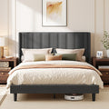 Slate grey upholstered king size bed with wingback headboard in a styled bedroom