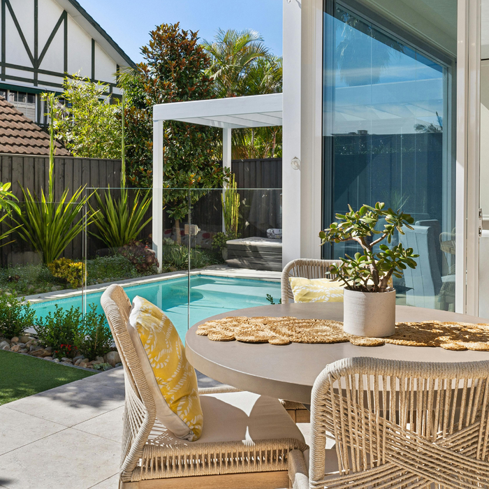 A modern garden with a patio and wicker patio dining set