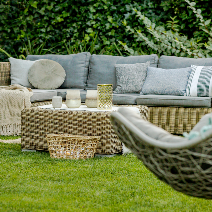 Cosy garden scene with rattan sofa and swing chair