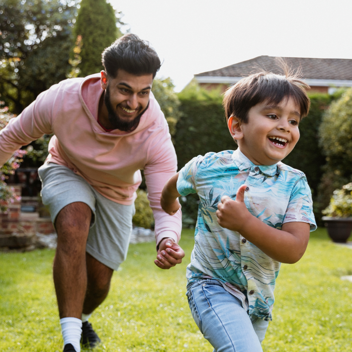 Man and his son playing chase game in the garden