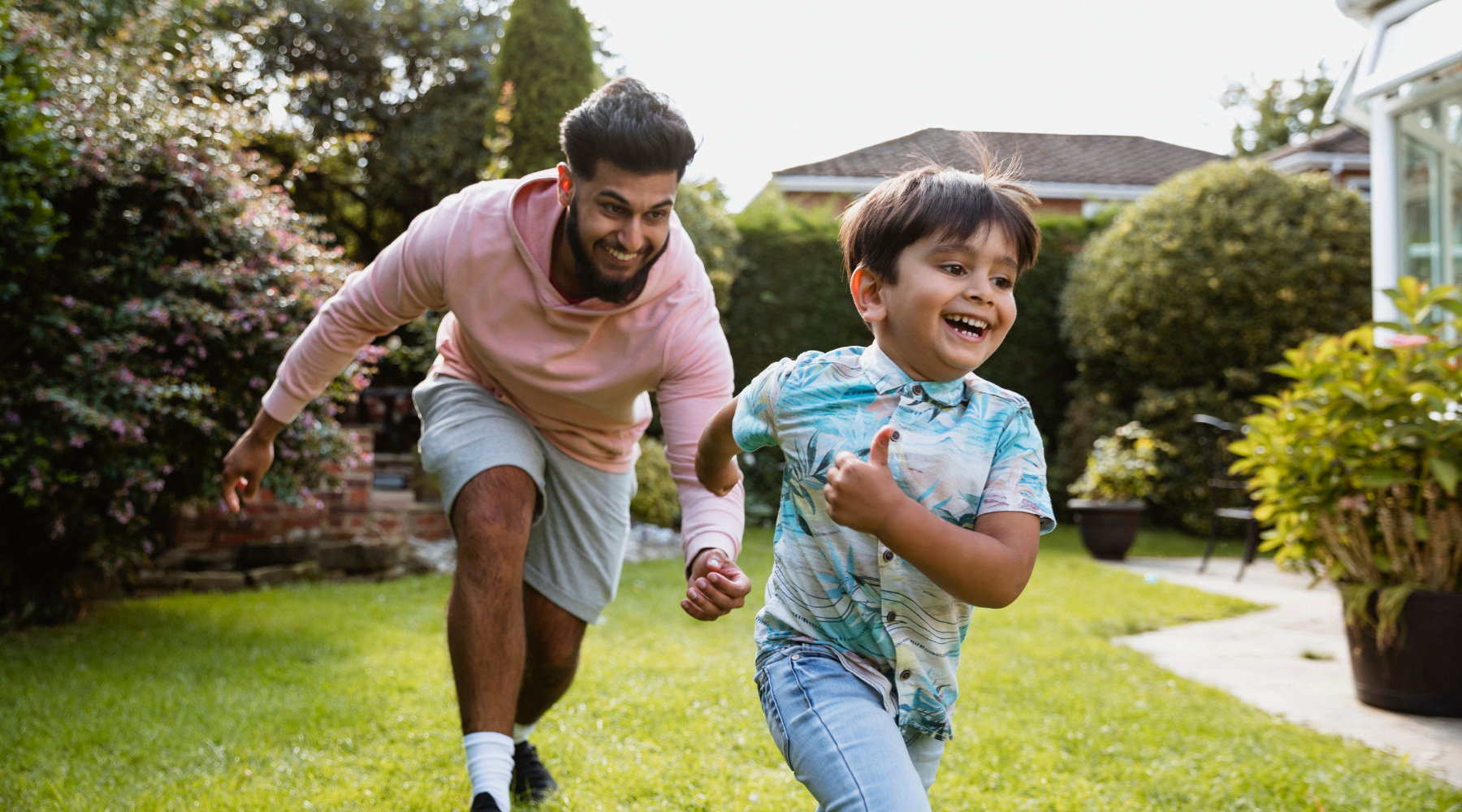 Man and his son playing chase game in the garden