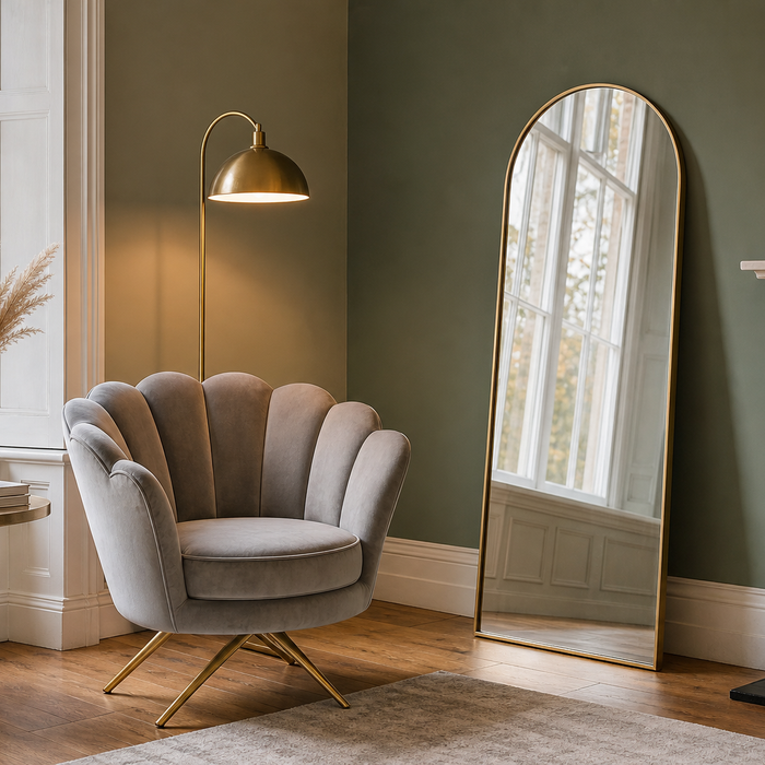 Art Deco-inspired living room styled with a velvet gold-leg accent chair, brass lamp and arched gold mirror