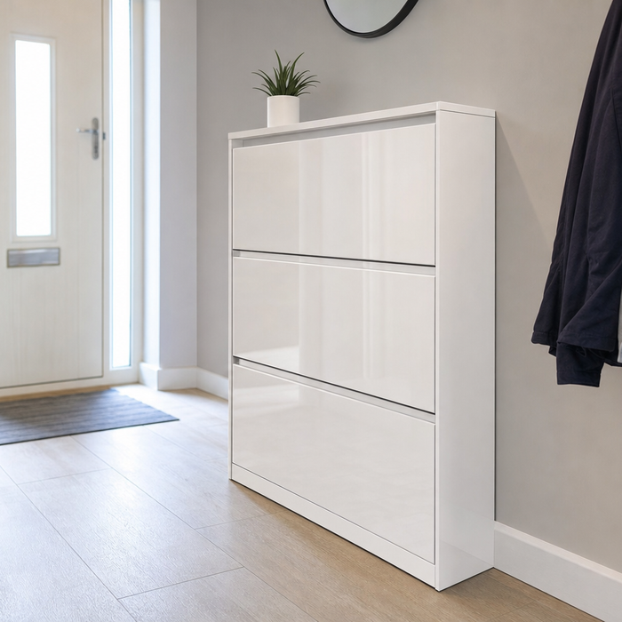 Slim white shoe cabinet with flip drawers in a modern UK hallway with coat hooks and tiled floor