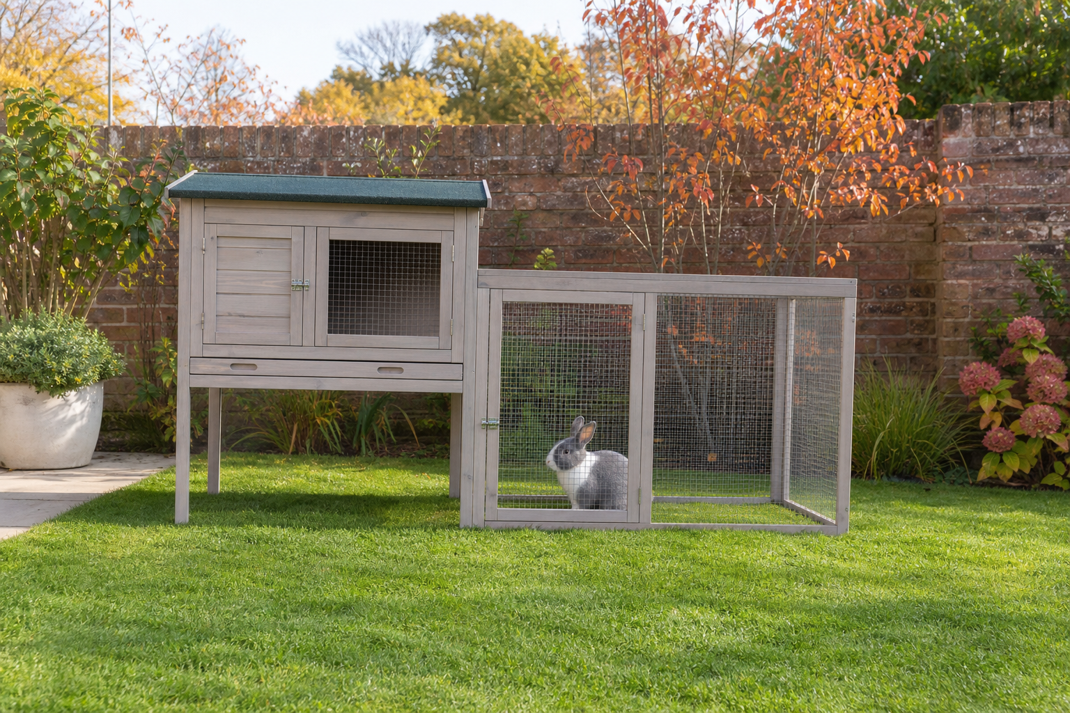 Raised wooden outdoor rabbit hutch with a run on a UK lawn in autumn sunshine