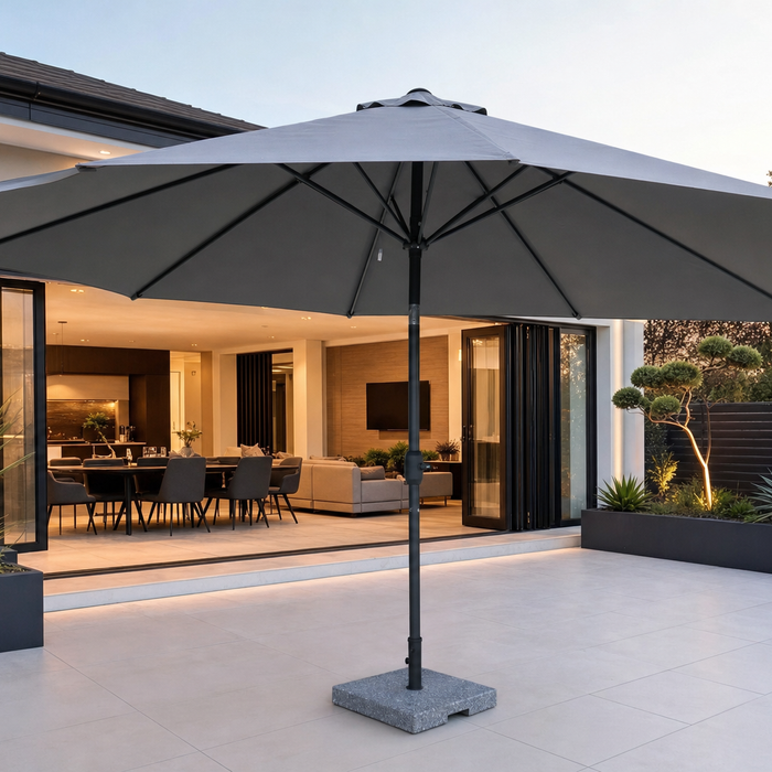 Grey 3m garden parasol with a weighted stone parasol base on a porcelain patio in a British garden