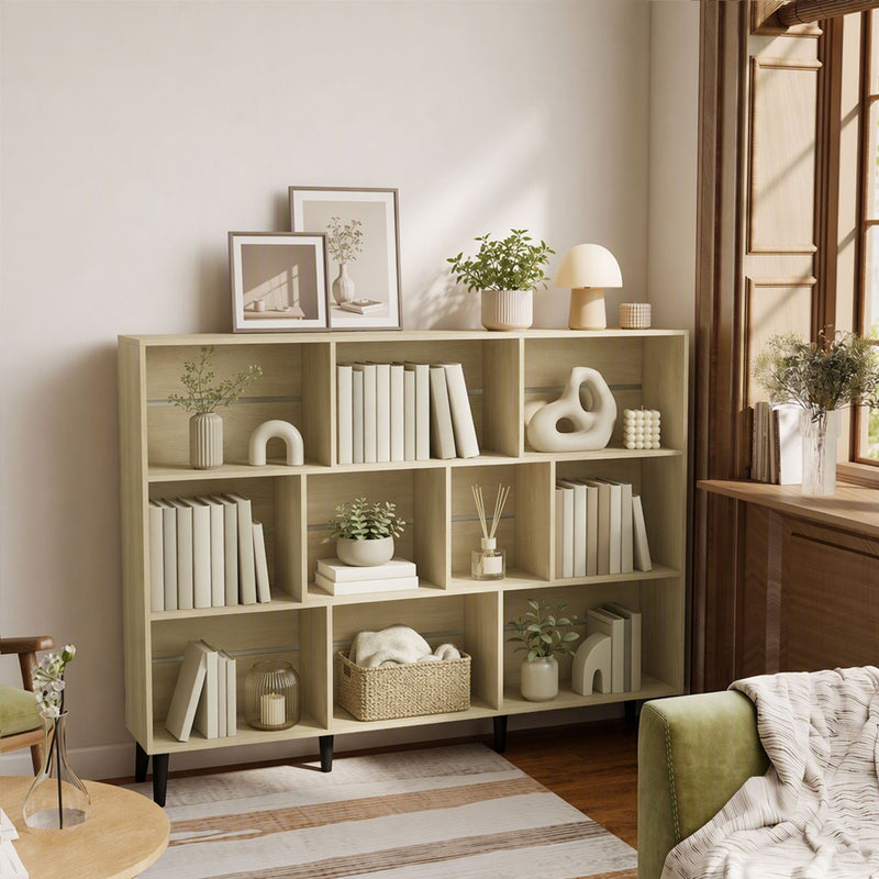 Oak 10-cube bookcase near a window with books and framed art on top