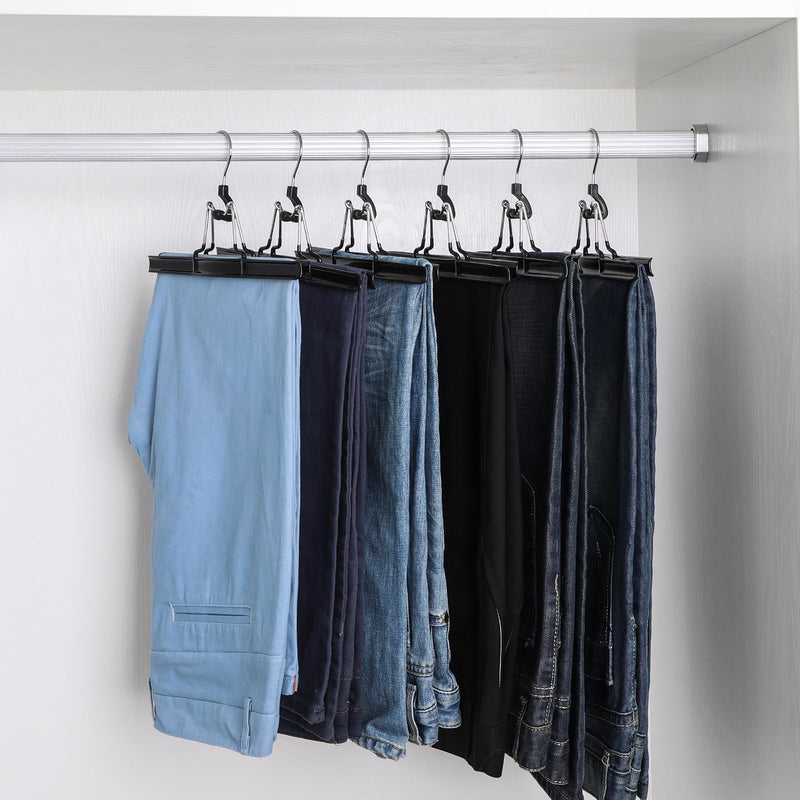 Row of black clamp hangers holding jeans and trousers on a white wardrobe rail