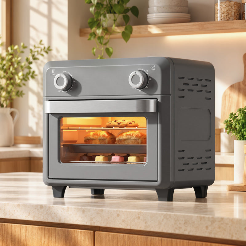 Grey air fryer oven on a kitchen worktop with food baking inside