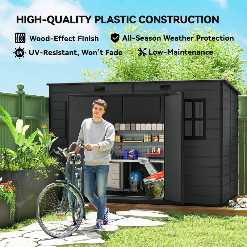 Man wheeling a bike past the dark grey garden storage shed, highlighting the wood-effect UV-resistant panels