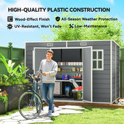 Man wheeling a bike past the grey garden storage shed, highlighting the wood-effect UV-resistant panels