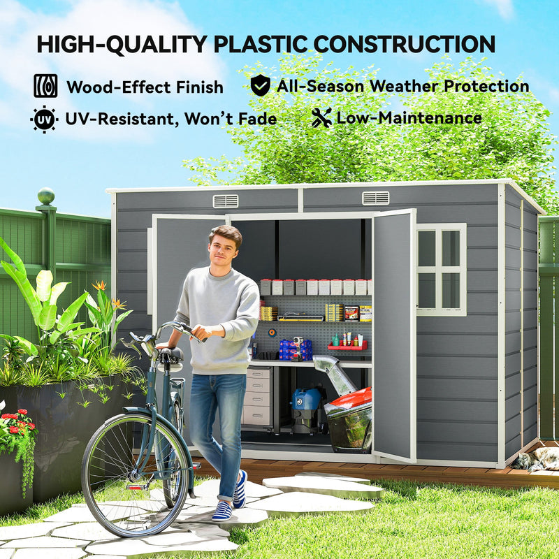 Man wheeling a bike past the grey garden storage shed, highlighting the wood-effect UV-resistant panels