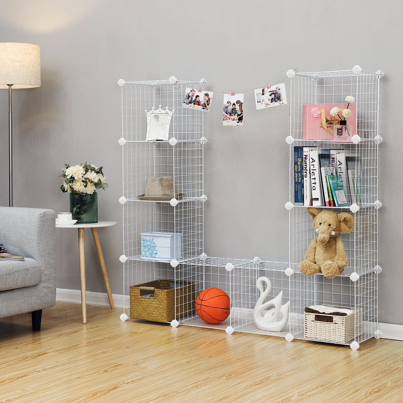 White cube organiser used as a living room display unit beside an armchair, holding photos and books