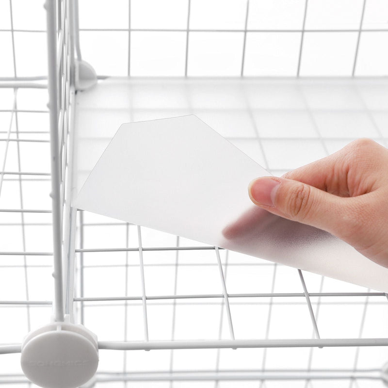 Close-up of a hand lifting a white base panel out of the white wire mesh frame