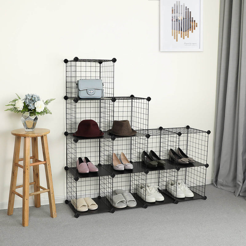 Black cube organiser built as a low stepped run beside a wooden stool, holding hats and shoes