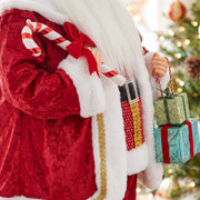 Close-up of the velvet suit, candy cane and gift boxes