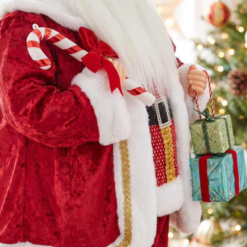 Close-up of the velvet suit, candy cane and gift boxes