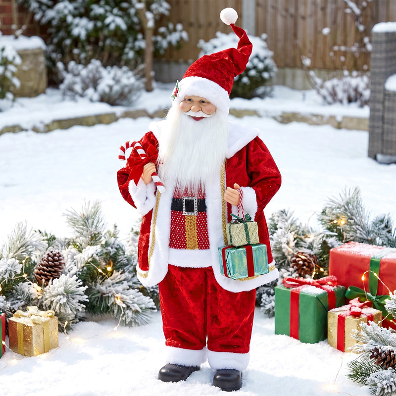Santa Claus figure outdoors in the snow among wrapped gifts