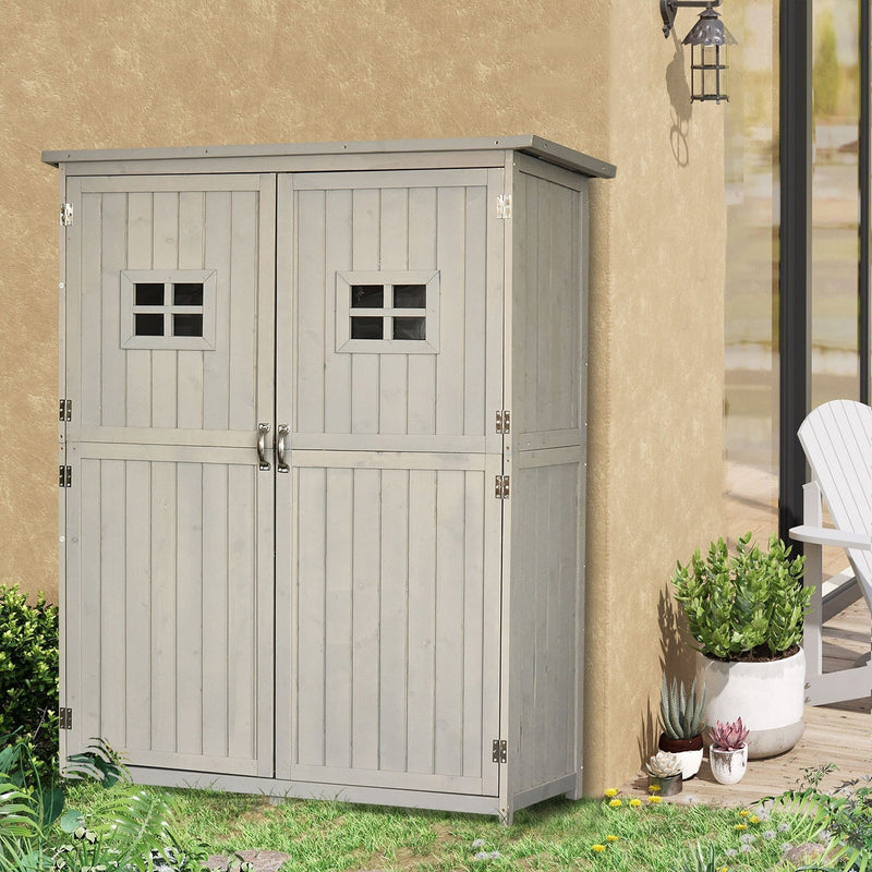 Grey wooden garden shed against a rendered wall beside a wall lantern