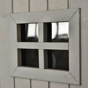 Close-up of a four-pane window set into the grey shed door