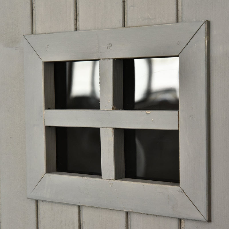 Close-up of a four-pane window set into the grey shed door