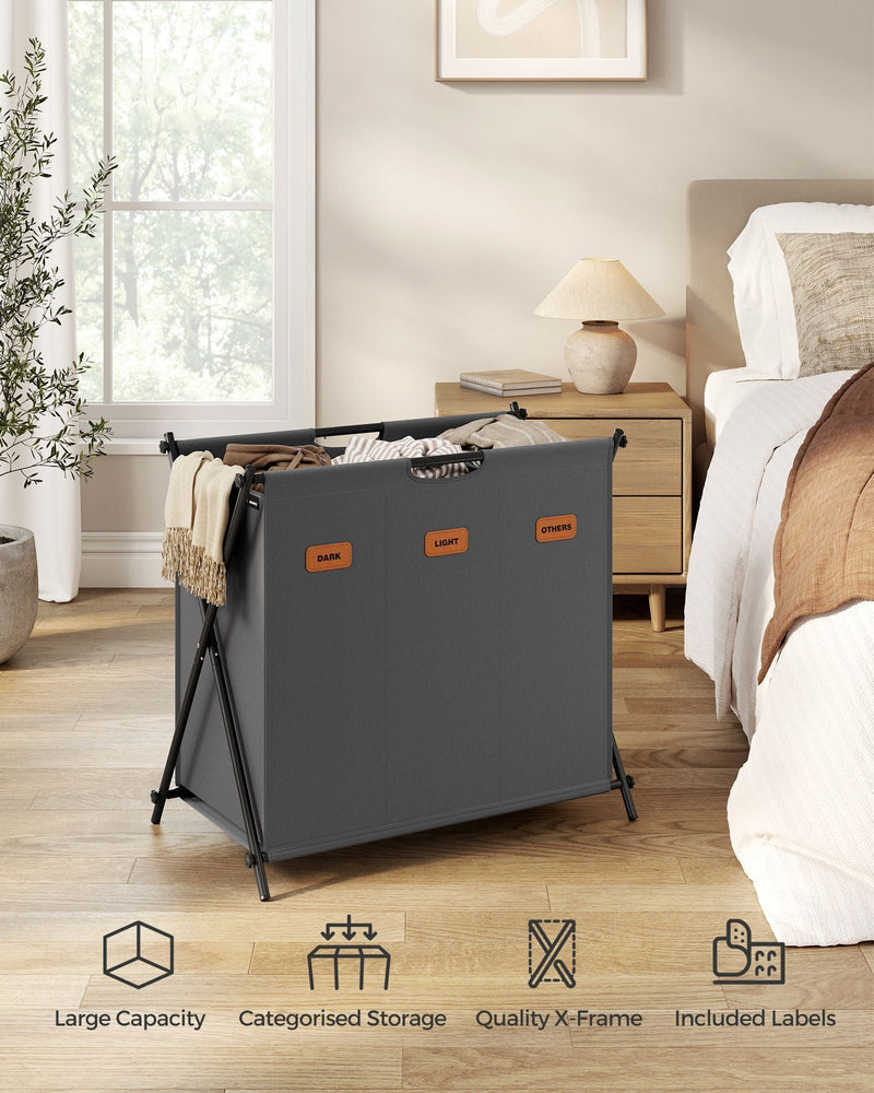 Songmics laundry hamper styled in a bedroom next to a bed