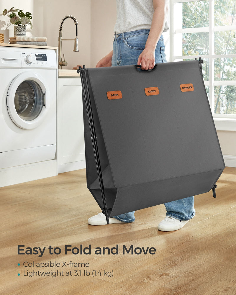 Songmics laundry hamper folded flat and being carried