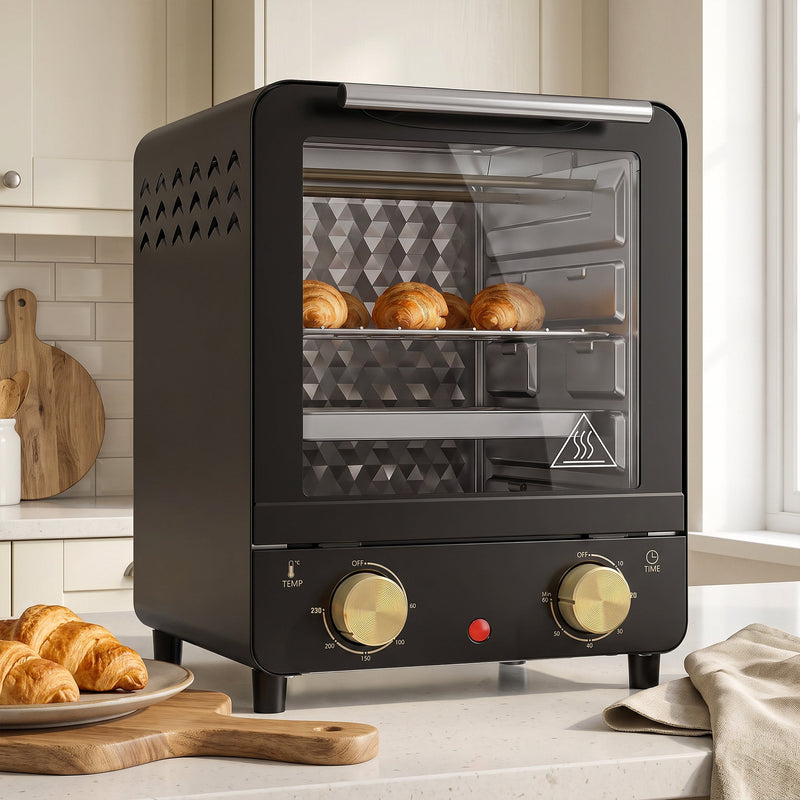 Black mini oven on a worktop with golden pastries baking inside