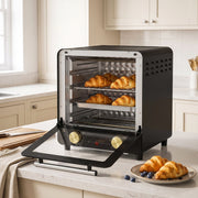 Black mini oven on a kitchen worktop with croissants and the door open