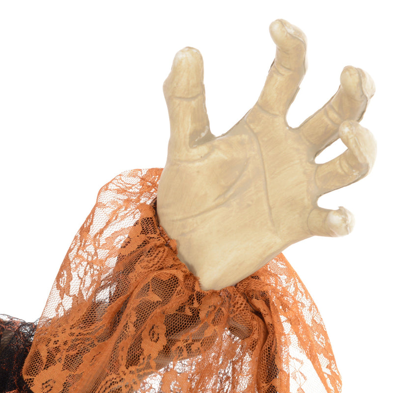 Close-up of the witch's clawed hand holding tattered fabric