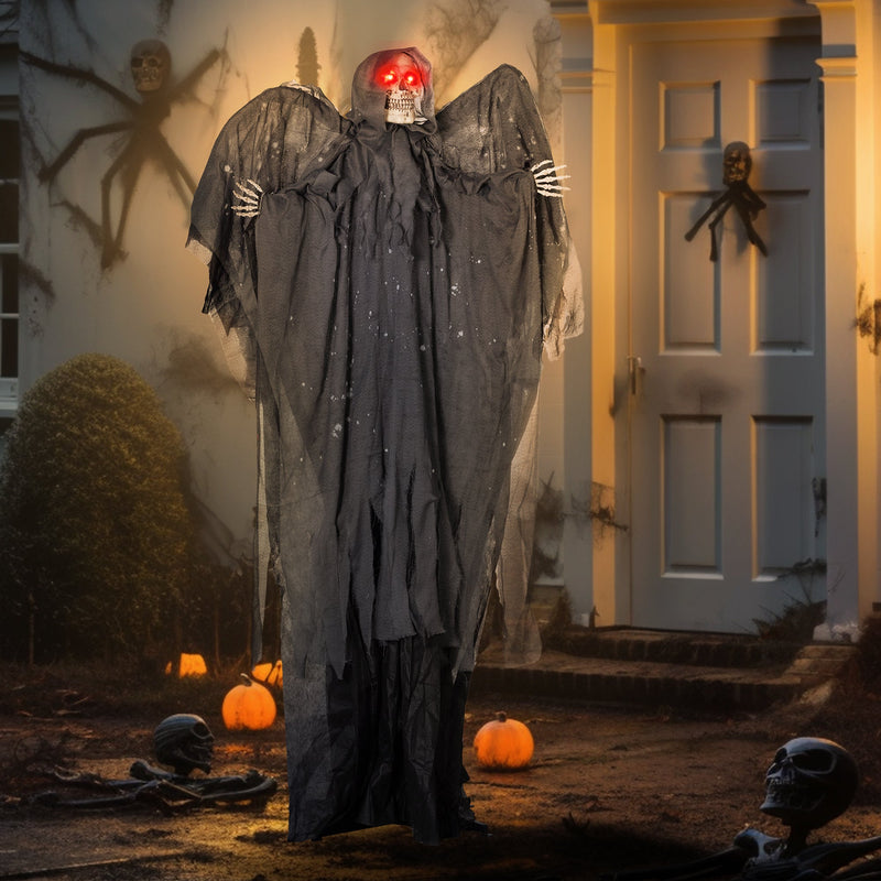 Winged grim reaper animatronic on a porch at night with pumpkins