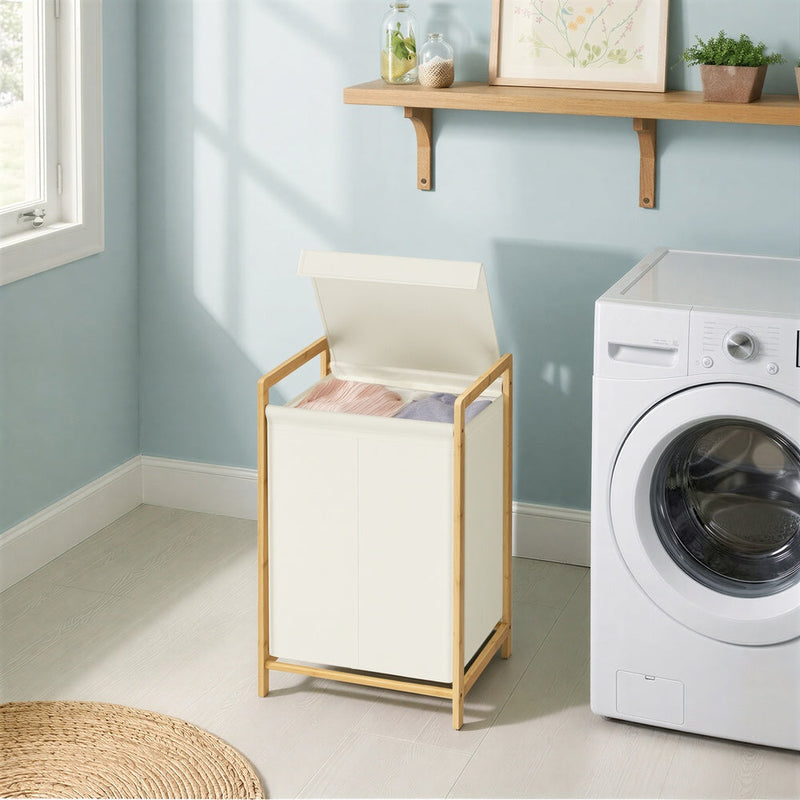 The bamboo laundry sorter beside a washing machine in a blue laundry room