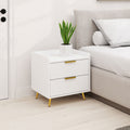 Bedside table with fluted drawers beside a bed with a potted plant on top in a light bedroom