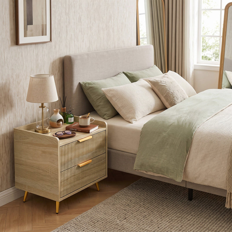 Angled view of the bedside table in a bedroom beside an upholstered headboard