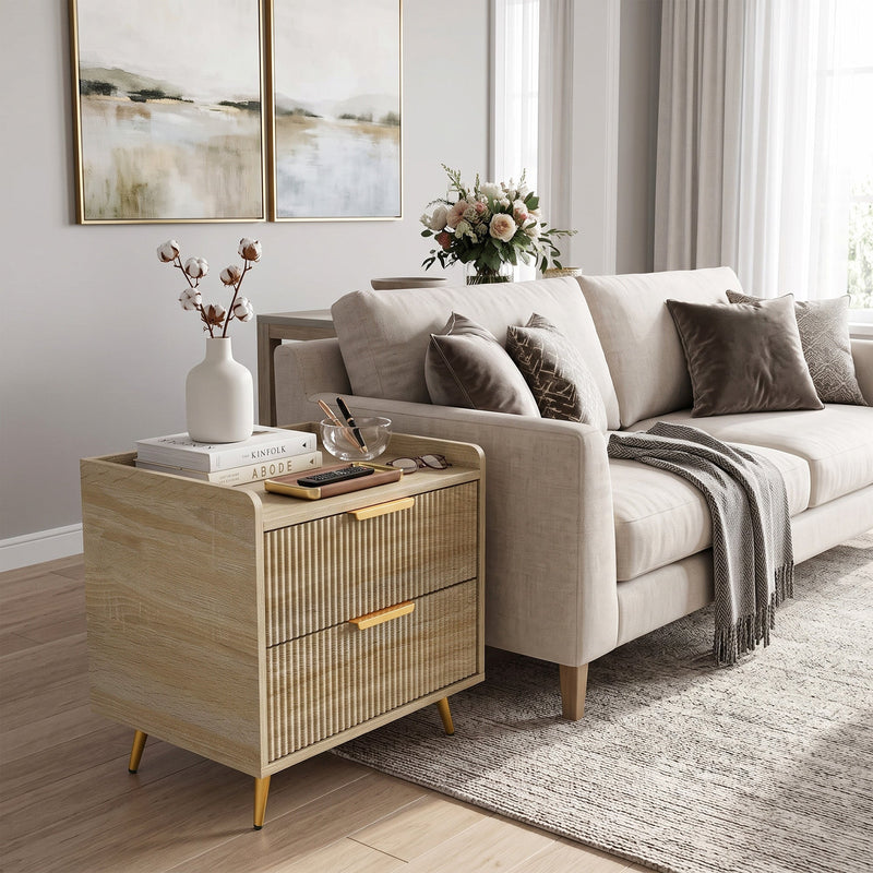 Bedside table placed at the end of a sofa with a vase of flowers on top