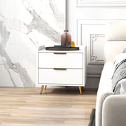 Bedside table in a marble-walled bedroom beside a sofa with a decorative tray