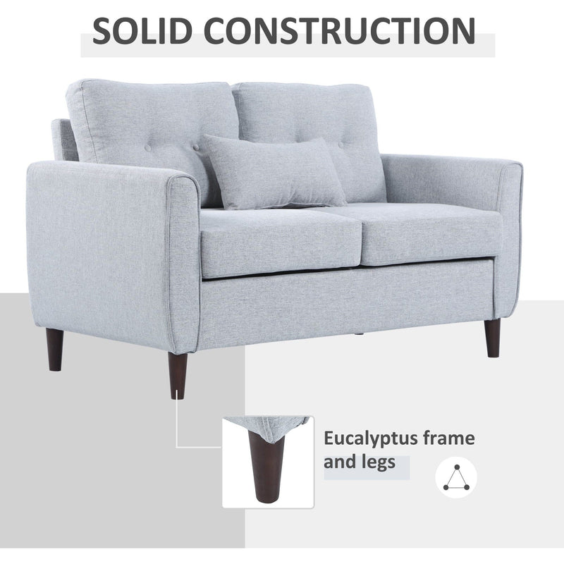 Grey sofa styled in a living room with picture frame and plant