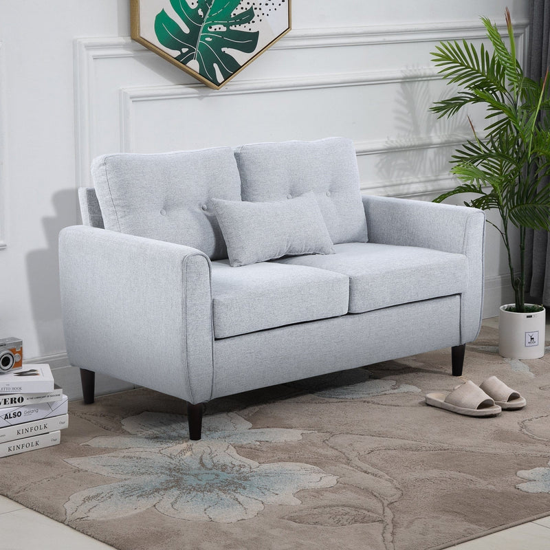 Grey tufted 2 seater fabric loveseat sofa in a modern living room