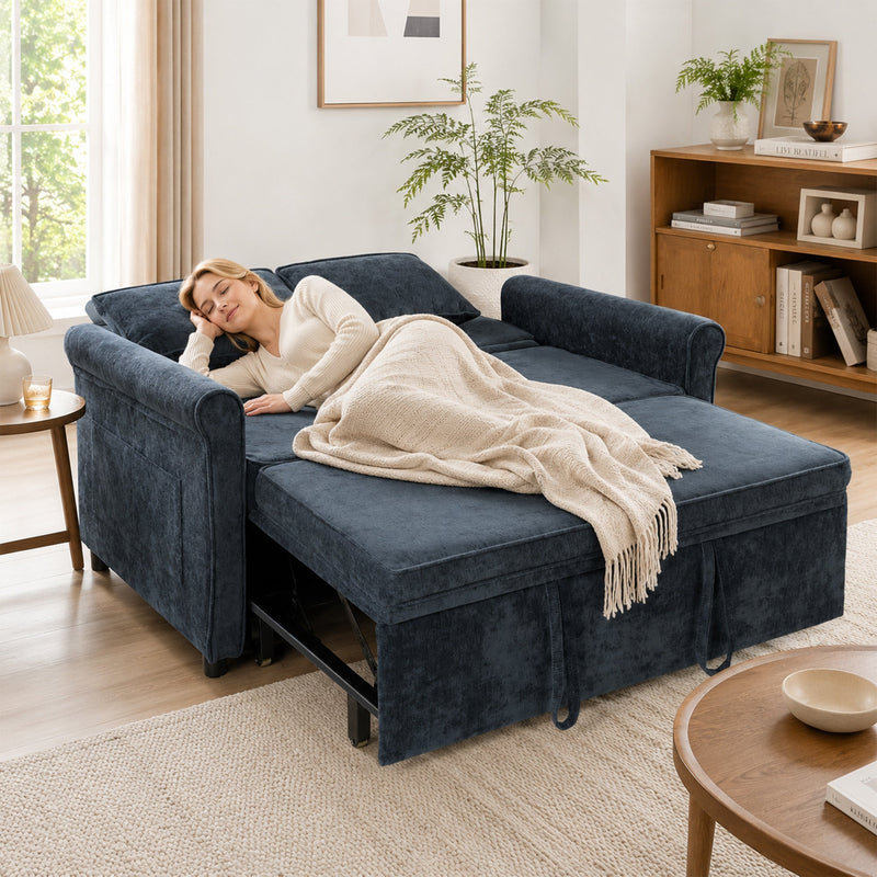 Woman napping under a throw on the dark blue sofa bed extended flat as a guest bed
